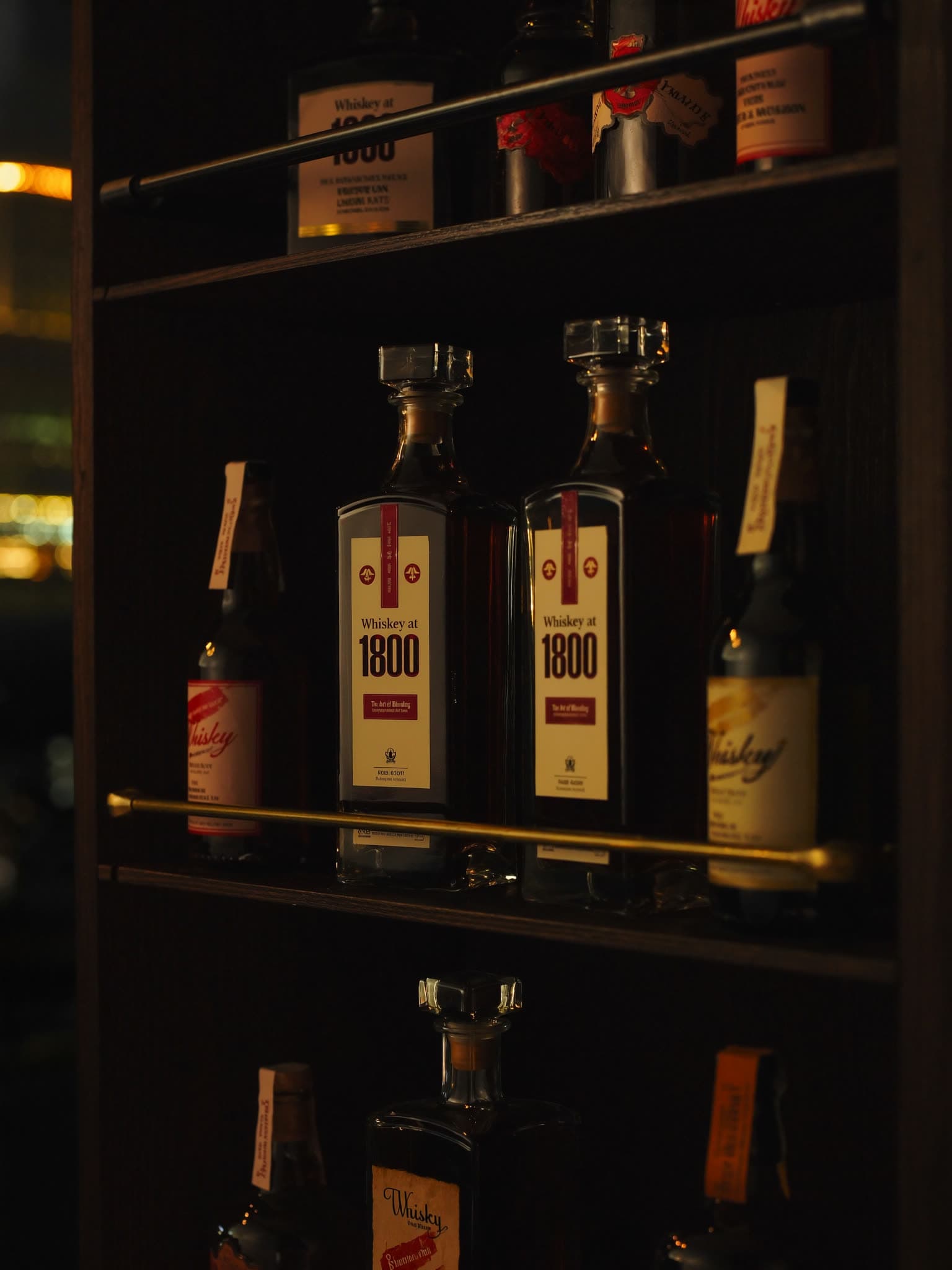 Bottles on the lit shelves of the back bar